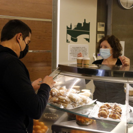 Un client del bar Pont de Pedra de Girona s'emporta dos cafès per esmorzar.