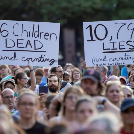 Manifestantes sostienen carteles en los que se leen "6 niños muertos y contando" (i) y "10.796 mentiras y contando" (d) -en referencia al presidente Trump- durante una manifestación este viernes, fuera de la Casa Blanca, en Washington (EE.U