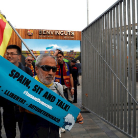 18/12/2019.- Un hombre sostiene una pancarta de "Tsunami Democràtic" en los aledaños del Camp Nou. / EFE - TONI ALBIR