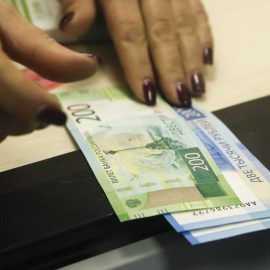 Una cajera con billetes de 200 y de 2.000 rublos, en un banco de Moscu. REUTERS/Maxim Shemetov