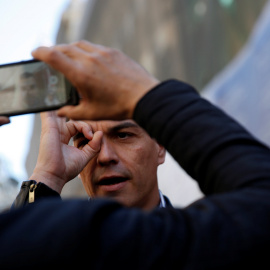 El líder socialista, Pedro Sánchez, hace un gesto mientras le toman una foto con un móvil, en la jornada del Primero de Mayo, en Madrid. REUTERS/Susana Vera