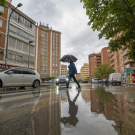 Un hombre se protege de la lluvia bajo un paraguas en Teruel, a 24 de mayo de 2023.