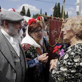 La alcaldesa de Madrid, Manuela Carmena, conversa con unos chulapos durante la romería con motivo de la festividad de San Isidro, patrón de la ciudad, en la Pradera de San Isidro. EFE/Emilio Naranjo
