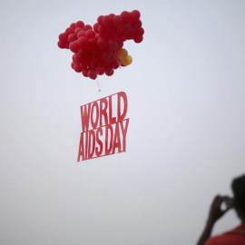 Activistas participan en una campaña de concienciación sobre el virus del sida, en la víspera del Día Mundial de la lucha contra esa enfermedad, junto al río Ganges en Calcuta, la India./ EFE