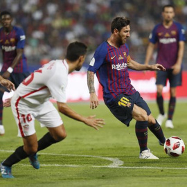 El delantero argentino del FC Barcelona Leo Messi (d) juega un balón ante Jesús Navas (c) y Gabriel Mercado, ambos del Sevilla, durante la Supercopa. EFE