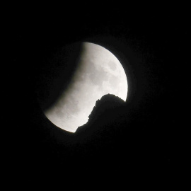 La luna se ve durante un eclipse lunar parcial detrás de un pico en los Alpes suizos del noreste, cerca de Urnaesch, Suiza, el 16 de julio de 2019. Foto tomada el 16 de julio de 2019. REUTERS / Arnd Wiegmann