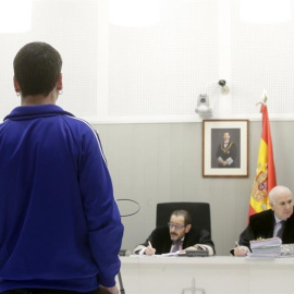 Jon Vicente Egurcegui (de espaldas) declarando en la Audiencia Nacional por publicar de forma continuada en redes sociales comentarios en los que ensalzaba a la banda terrorista ETA. EFE/Zipi