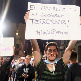 Un hombre sostiene un cartel durante una protesta en Buenos Aires. | MIREIA SEGARRA (EFE)