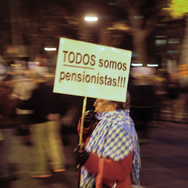 Una anciana con una pancarta que dice 'Todos somos pensionistas', en una manifestación contra las medidas del Gobierno. AFP / Pedro Armeste