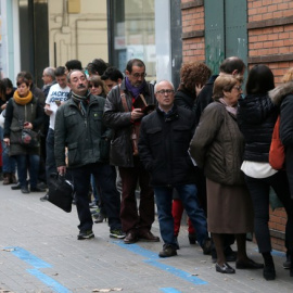 Varias personas hacen cola para votar en un colegio de Barcelona minutos antes de que abra sus puertas. /REUTERS