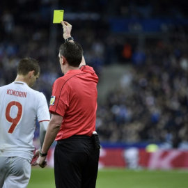 Un árbitro enseña tarjeta amarilla al ruso Kokorin en el amistoso contra Francia en Saint Denis en marzo. /AFP