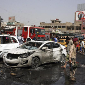 Decenas de personas inspeccionan el lugar donde fue perpetrado uno de los tres atentados de este martes en Bagdad.- EFE