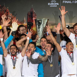 Jugadores y cuerpo técnico del Sevilla celebran con el trofeo de la Liga Europa. /EFE