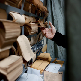 Un hombre escoge papeletas en el colegio electoral de Chozas de la Sierra en Soto del Real, Madrid, este domingo durante las elecciones municipales y autonómicas.