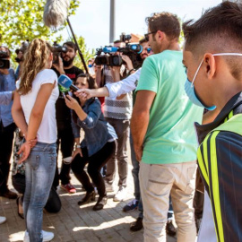 Padres del colegio Juan Carlos I en Seseña, atienden a los medios de comunicación, a su llegada a la recogida del alumnado con máscaras protectoras. /EFE