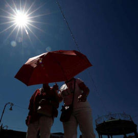 Dos mujeres se protegen con un paraguas de sol en Pamplona. (JESÚS DIGES | EFE)