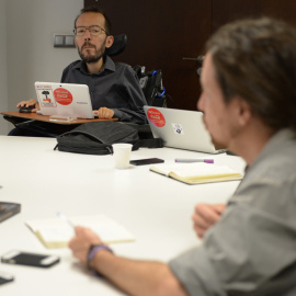 El líder de Podemos en Aragón, Pablo Echenique, escucha a Pablo Iglesias, duirante la reunión con los líderes regionales de la formación para debatir la estrategia de pactos tras el 24-M.