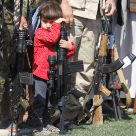 Un niño descansa apoyado sobre un arma en Yemen./REUTERS