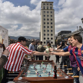 Aficionados del Barça y del Athletic emulan el partido en un futbolín. /EFE