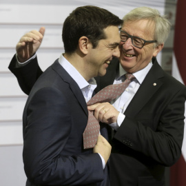 El presidente de la Comisión Europea,  Jean-Claude Juncker, saluda cordialmente al primer ministro griego, Alexis Tsipras, a su llegada a la última reunión de la UE en Riga. REUTERS/Ints Kalnins
