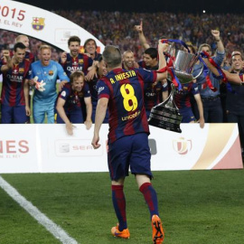 Xavi e Iniesta llevan la Copa del Rey al resto de sus compañeros. /EFE