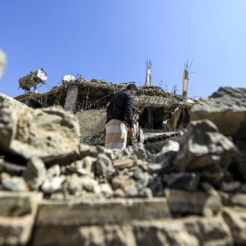 Un hombre busca entre los escombros de un edificio derruido tras un ataque aéreo de Arabia Saudí en Saná, la capital de Yemen. - AFP