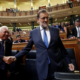 El presidente el Gobierno en funciones, Mariano Rajoy, se da un apretón de manos con Garcia-Margallo antes del debate de investidura en el Congreso de los Diputados. REUTERS/Juan Medina