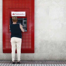 Una mujer saca dinero en un cajero del Banco Santander en Madrid. E.P./Eduardo Parra