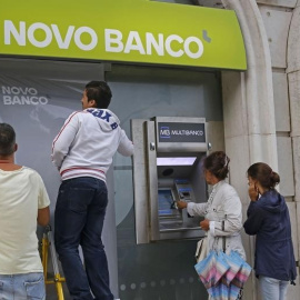 Dos operarios colocan el cartel de Novo Banco en una oficina de la entidad, en Lisboa. REUTERS