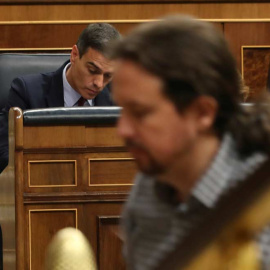 Pablo Iglesias, de camino a la tribuna del Congreso mientras Pedro Sánchez toma unas notas. (J.J. GUILLÉN | EFE)