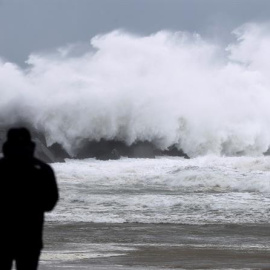 Un hombre observa una ola en el espigón del Kursaal de San Sebastián, durante el paso del temporal de invierno Bruno. - EFE