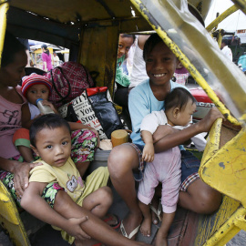 Una familia en su triciclo hacia un centro de evacuación en Manila. // EFE/EPA/DENNIS M. SABANGAN