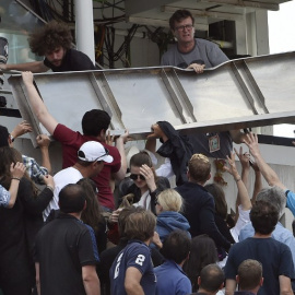 Espectadores intentan apartar la placa caída en la grada de la pista Phillipe Chatrier. /AFP