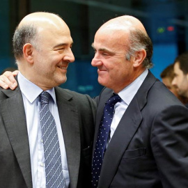 El comisario europeo de Asuntos Económicos, Pierre Moscovici, (i), conversa con el ministro español en funciones de Economía, Luis de Guindos (d) durante la reunión del Eurogrupo celebrada hoy en Bruselas.-  EFE/Olivier Hoslet