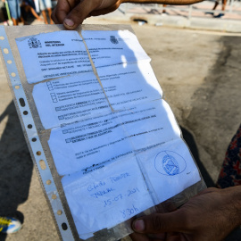 Un joven sostiene un documento de expediente de solicitud de asilo