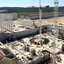 Imagen actual de las obras del ITER tomada por un drone desde 60 metros de altura. La estructura circular corresponde al reactor tokamak. Las columnas metálicas indican el edificio de montaje. Al fondo, el primer edificio terminado, destina