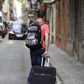 Dos personas con una maleta caminan por la calle. EFE
