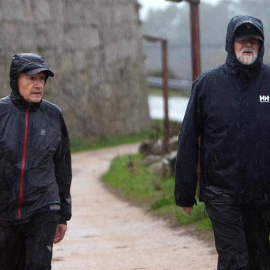 Mariano Rajoy, a la derecha de la imagen, camina bajo la lluvia acompañado del marido de Ana Pastor. |  SALVADOR SAS (EFE)