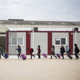 Alumnos del colegio público Ciudad de Cremona salen de los barracones al finalizar las clases. BIEL ALIÑO. EFE Valencia