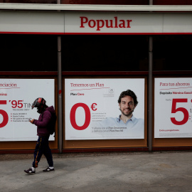 Un hombre con un casco de motorista pasa por delante de una sucursal del Banco Popular eb Madrid. REUTERS/Susana Vera