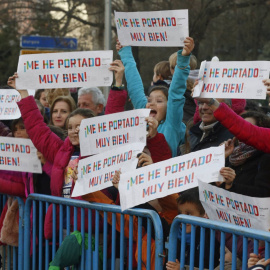 Niños disfrutando de la cabalgata de Reyes en Madrid con pancartas. EFE