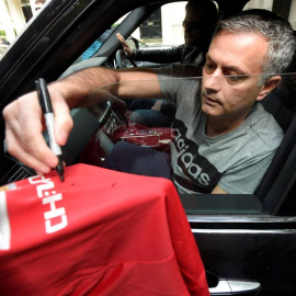Mourinho firma autógrafos a los aficionados del United. / REUTERS