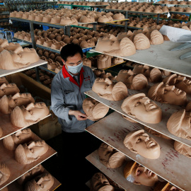 Trabajador de una factoría en China verifica una remesa de máscaras del rostro del que se postula como líder republicano de cara a las elecciones presidenciales de EEUU.- REUTERS