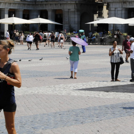 12/07/2022-Personas se protegen del calor el 12 de julio en una jornada marcada por las altas temperaturas, en la Plaza de Mayor de Madrid