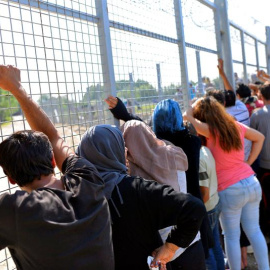Un grupo de refugiados espera para cruzar la frontera entre Serbia y Hungría en un campamento situado cerca del puesto de Horgos, en Serbia hoy.-EFE/Edvard Molnar