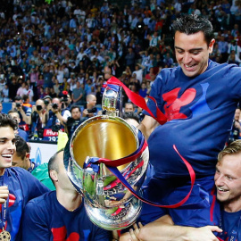 Xavi, con la copa y el balón, levantado por Bartra, Iniesta y Rakitic. Reuters / Kai Pfaffenbach