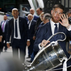El capitán del Real Madrid Sergio Ramos sostienen el trofeo que acredita al equipo blanco como vencedor de la Liga de Campeones, logrado ayer tras imponerse en la final al Atlético de Madrid en Milán, esta tarde a su llegada a la sede del a