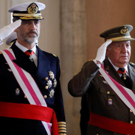 El Rey Felipe VI y el Rey emérito Juan Carlos, escuchan el himno nacional, a su llegada a la celebración hoy de la Pascua Militar en el Palacio Real. / EFE