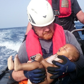 Un cooperante alemán de la organización humanitaria Sea-Watch sostiene el cuerpo de un bebé recogido del mar después de que el barco de refugiados en el que el viajaba naufragase en el Mediterráneo. REUTERS