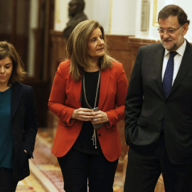 Mariano Rajoy con la ministra de Empleo, Fátima Bañez, y la vicepresidenta Soraya Sáenz de Santamaría, en los pasillos del Congreso de los Diputados. EFE
